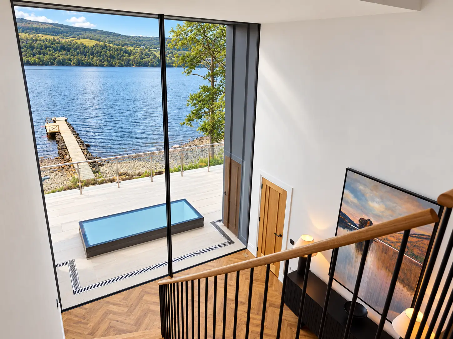 Full-height window above the stairs looking over the terrace to the private jetty